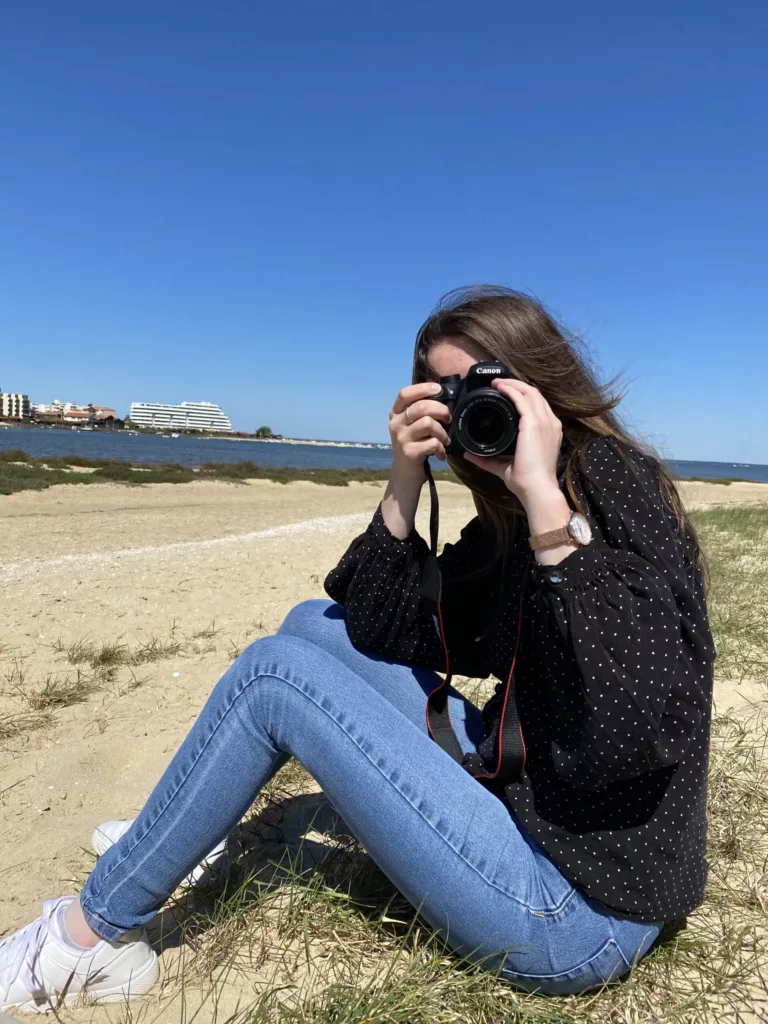 Photo de Elsa, prenant une photo de la personne qui la prend en photo, pour la page à propos.